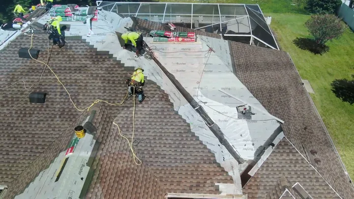 An aerial view of a roofing crew re-roofing a house